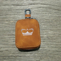 A small brown leather zippered pouch with a silver metal key ring and a crown logo on the front.